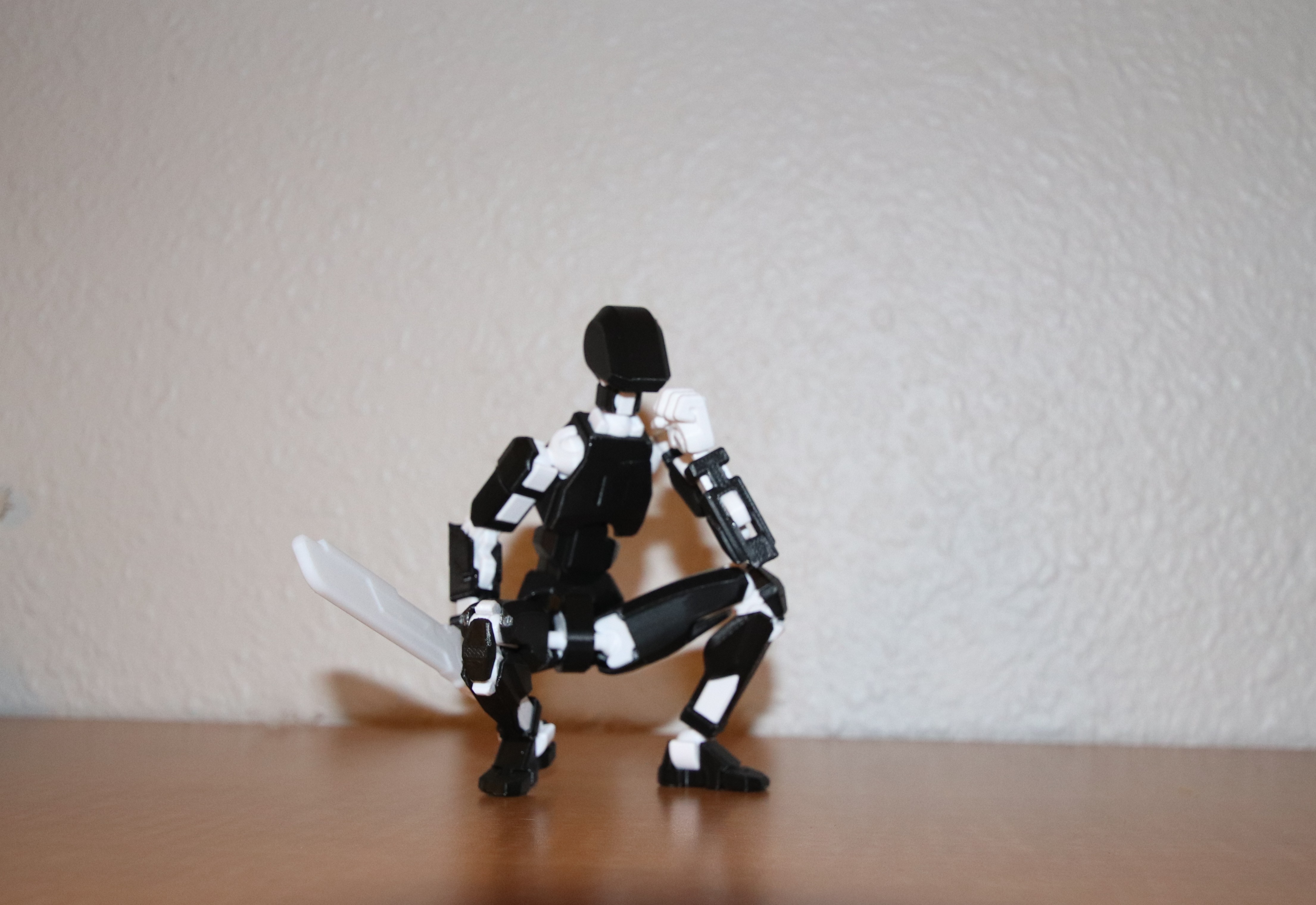 Dummy 13 'Panda' — black and white figure in a crouched thinking pose, fist on chin, sword in hand